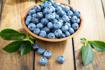 Blueberries in a plate and pancakes, on an old background.