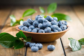 Blueberries in a plate and pancakes, on an old background.