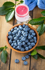 Blueberries in a plate and pancakes, on an old background.