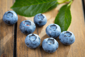 Blueberries in a plate and pancakes, on an old background.