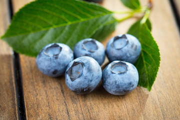 Blueberries in a plate and pancakes, on an old background.