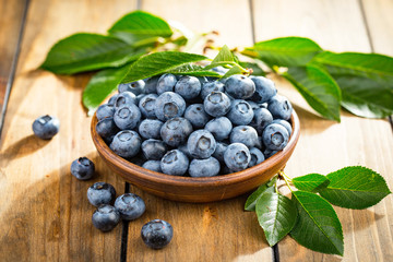 Blueberries in a plate and pancakes, on an old background.