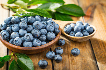 Blueberries in a plate and pancakes, on an old background.