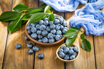 Blueberries in a plate and pancakes, on an old background.