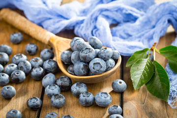 Blueberries in a plate and pancakes, on an old background.