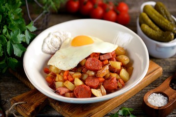 Fried potatoes with smoked meat and chorizo with garlic, onions, carrots and eggs.