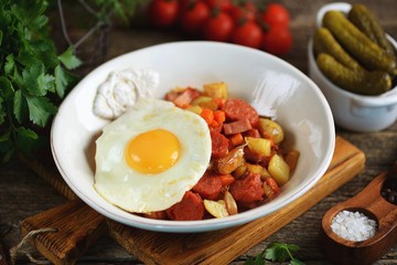 Fried potatoes with smoked meat and chorizo with garlic, onions, carrots and eggs.