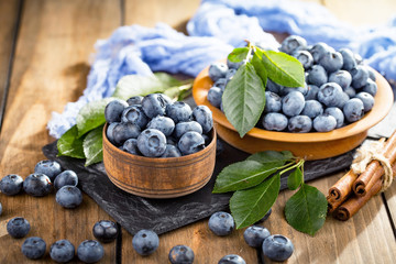 Blueberries in a plate and pancakes, on an old background.