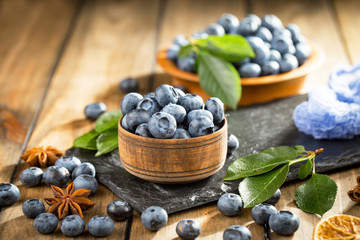 Blueberries in a plate and pancakes, on an old background.