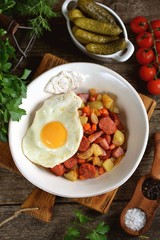Fried potatoes with smoked meat and chorizo with garlic, onions, carrots and eggs.