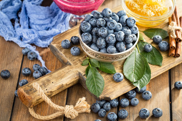 Blueberries in a plate and pancakes, on an old background.