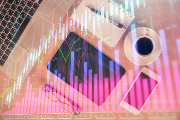 Double exposure of financial graph hologram over desktop with phone. Top view. Mobile trade platform concept.