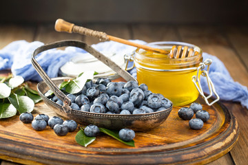 Blueberries in a plate and pancakes, on an old background.
