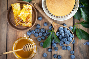 Blueberries in a plate and pancakes, on an old background.