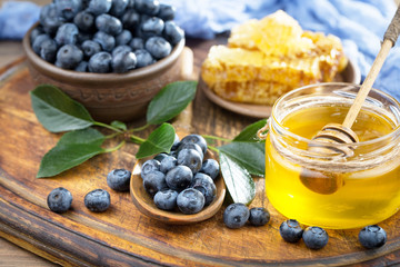 Blueberries in a plate and pancakes, on an old background.