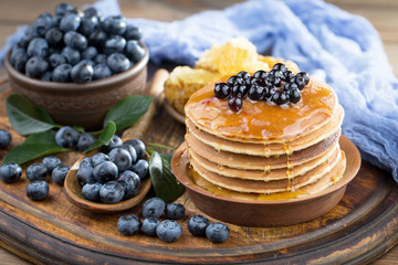 Ripe, fresh blueberries in a wooden bowl on an old background.