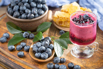 Blueberries in a plate and pancakes, on an old background.