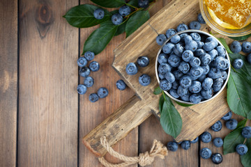 Blueberries in a plate and pancakes, on an old background.