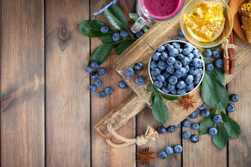 Blueberries in a plate and pancakes, on an old background.