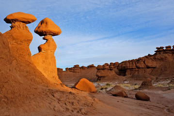 Balanced rock hoodoos in goblin valley Utah are illuminated by spotlighting from the setting sun.