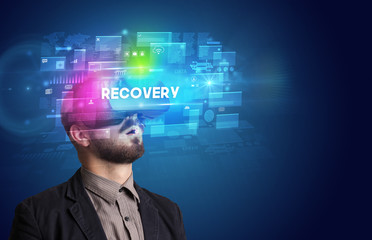 Businessman looking through Virtual Reality glasses with RECOVERY inscription, innovative security concept