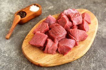Fresh raw organic beef slices on a cutting board.