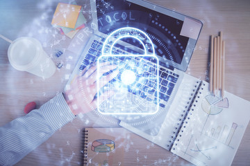 Multi exposure of man's hands typing over computer keyboard and lock hologram drawing. Top view. Technology concept.