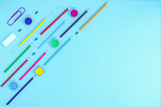 Office supplies paper clips, paints, pencils and pens lie in a line on a light blue background. back to school, school year at school, university, kindergarten. Place for text