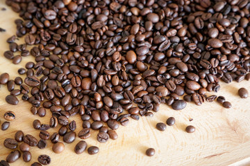 Coffee grains on wooden table, with natural light
