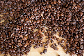 Coffee grains on wooden table, with natural light