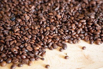 Coffee grains on wooden table, with natural light
