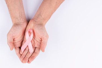 Hands holding pink ribbon. White background.