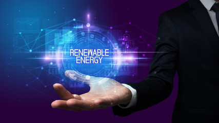 Man hand holding RENEWABLE ENERGY inscription, technology concept