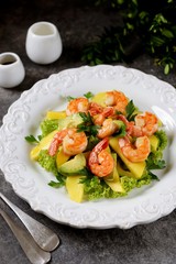 Salad with shrimp tails, lettuce, avocado, mango slice, parsley, olive oil and lemon juice. Healthly food.