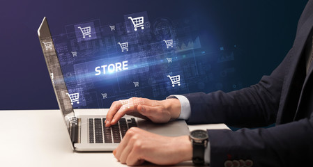 Businessman working on laptop with STORE inscription, online shopping concept