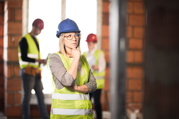 worker, investor, inspector or architect with her team. construction site engineers on site. satisfied expression