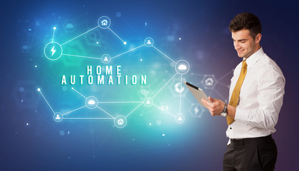 Businessman in front of cloud service icons with HOME AUTOMATION inscription, modern technology concept