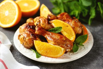 Chicken drumsticks baked with orange and mint. Organic food.