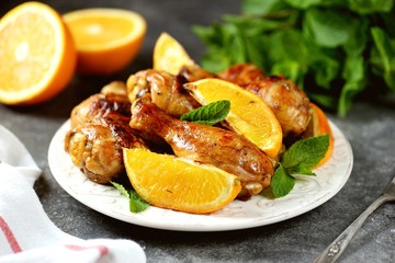 Chicken drumsticks baked with orange and mint. Organic food.