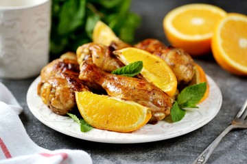 Chicken drumsticks baked with orange and mint. Organic food.
