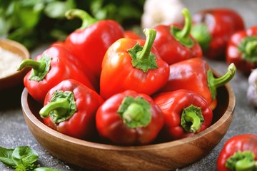 Organic bell peppers in a wooden plate.