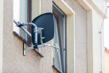 Satellitenschüssel im Fensterbereich eines Hauses angebracht