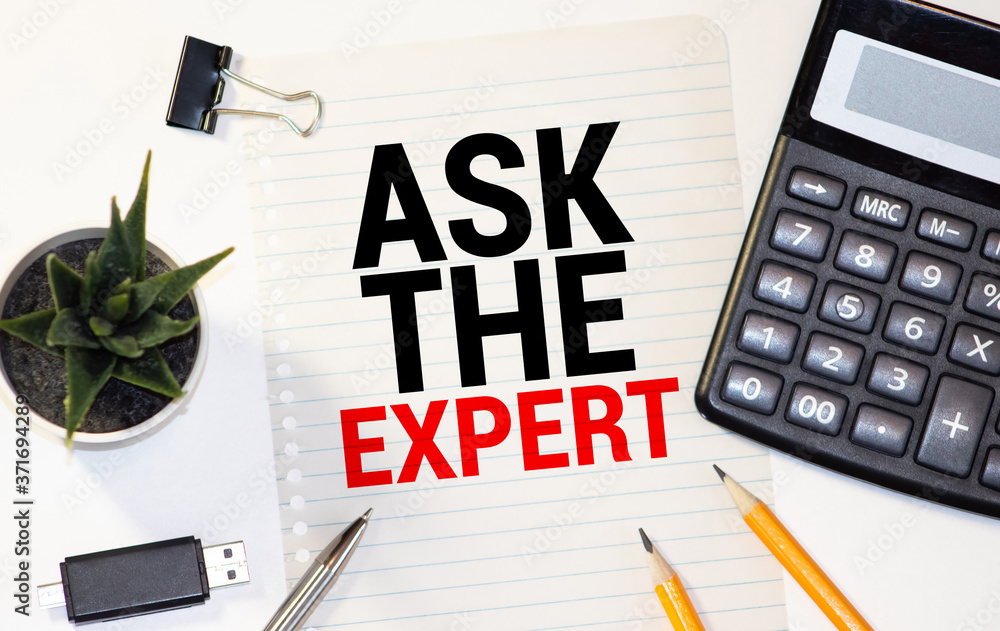 Poster ask an expert. top view of working place with ask an expert lettering at notepad.