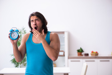 Young man waking up at home