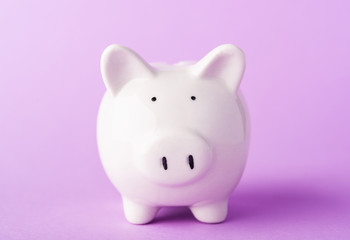 Front small white fat piggy bank, studio shot isolated on purple background and copy space for use, Finance, deposit saving money concept