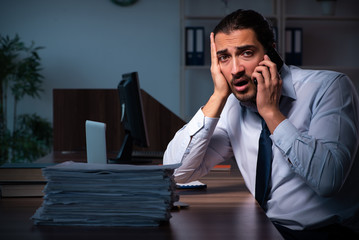 Young male employee working in the office night time