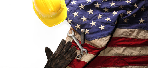 Hardhat, gloves, and tools on US American flag. Strong American workforce or industry, or America...
