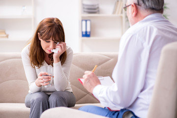 Fototapeta premium Young woman visiting old male doctor psychologist