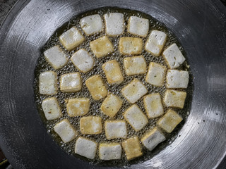 Cooking tofu on a hot big pan