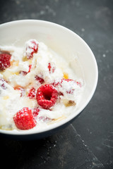 Healthy and tasty breakfast with curd, sour cream, raspberry and honey. Selective focus.